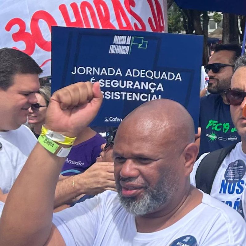 Wagner Batista de punho erguido em ato da Enfermagem, diante de uma faixa pelas 30 horas