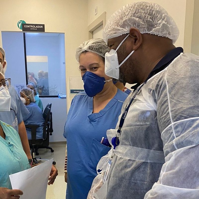 Wagner Batista paramentado, conversando com profissionais de saúde dentro do hospital