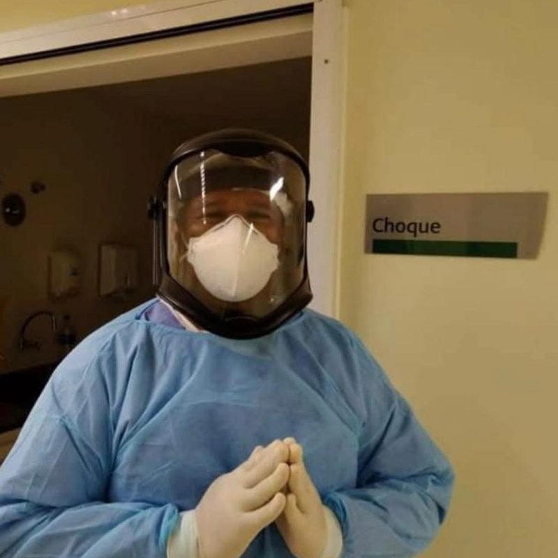 Profissional de saúde paramentado com avental, máscara e protetor facial